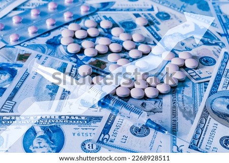 Medicine pills and hypodermic needle with dollars and arrow up. The concept of growth in the production of medicine pills or prices for them. Growth in sales, demand and purchases of a pills. 