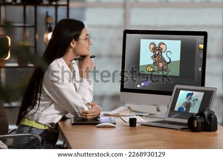 Animator working with computer and laptop. Illustrations on screens Royalty-Free Stock Photo #2268930129