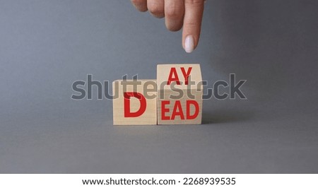 Day of the Dead symbol. Businessman hand points at turned wooden cubes with words Day of the Dead. Beautiful grey background. Day of the Dead concept. Copy space.