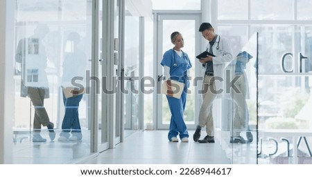 Healthcare, nurse and doctor talking, walking in lobby and consultation for advice, diagnosis and tablet. Medical professionals, Asian man and woman in hospital, update charts or planning for surgery Royalty-Free Stock Photo #2268944617