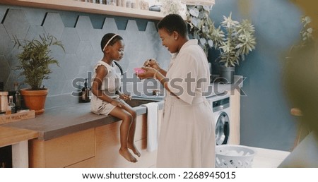 Mother, child and breakfast with mom feeding girl food for nutrition, growth health and wellness in home kitchen. Black woman with girl at family house for quality time, love and eating healthy Royalty-Free Stock Photo #2268945015