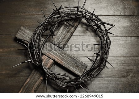 Crown of thorns with cross on dark wooden background Royalty-Free Stock Photo #2268949015