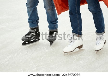 Cropped image of male and female legs in skates, skating on ice-rink. Active weekends. Concept of leisure activity, winter hobby and sport, vacation, fun, relationship, emotions.