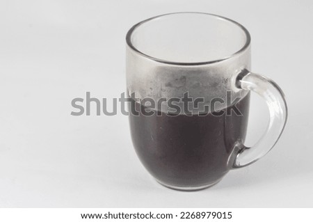 A glass of black coffee isolated on a white background.
