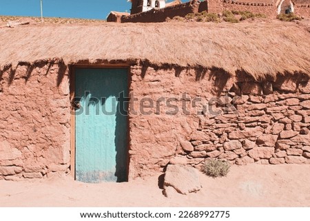 Old adobe house blue door in the Altiplano Machuca Chile Royalty-Free Stock Photo #2268992775