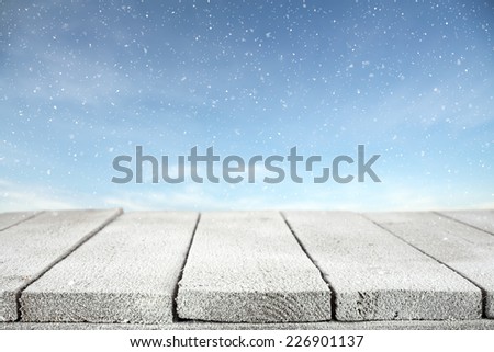 winter photo of blue sky with snow and table with frost 