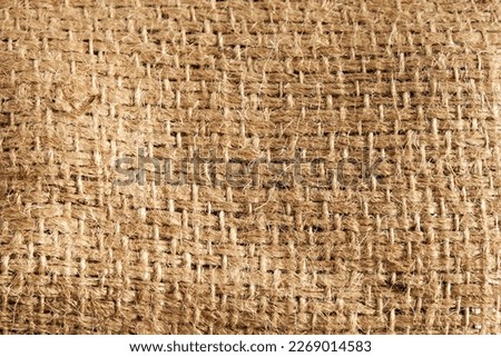 Detailed natural burlap background. The texture of the fabric of a brown coarse belt. Close-up Royalty-Free Stock Photo #2269014583