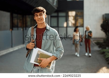 Young student in front of university building looking at camera. Royalty-Free Stock Photo #2269023225