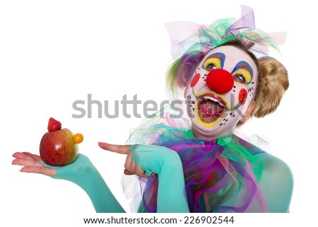 Clown laughs about the small nose of a fruit manikin