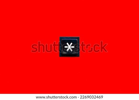 One single asterisk symbol star sign square button key on bright red background abstract scene, object top view, closeup. Star special symbol *, isolated. Password, unknown letter, character concept