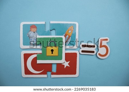 Red and white colored crescent and star puzzle, astronaut picture puzzle, space shuttle puzzle, lock picture puzzle and equals five text placed on a blue background.