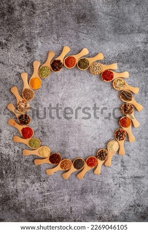 Pattern of spices on a gray background. A set of spices from India. Decoration design. Various spices, peppers and herbs close-up top view. A set of peppers and spices for cooking.