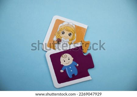Colorful puzzle pieces with pictures of bride and baby placed on a blue background.