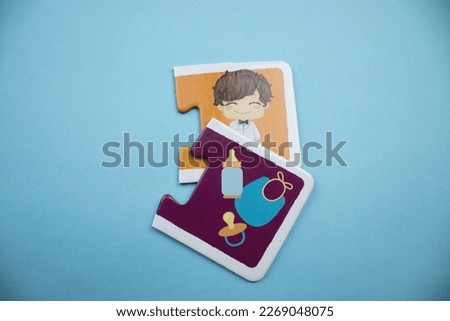 Colorful jigsaw puzzle pieces with pictures of groom and baby supplies placed on a blue background.