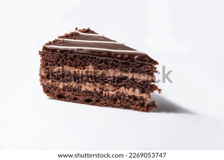 A piece of chocolate cake with cream on a white background. Royalty-Free Stock Photo #2269053747