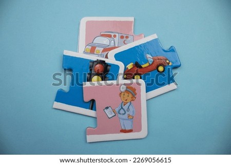 Ambulance, traffic signs, car and doctor, picture puzzle pieces placed on blue background.