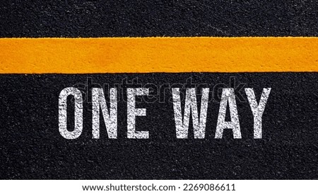 One way text written and yellow line on the road in middle of the asphalt road, One way word on street.
