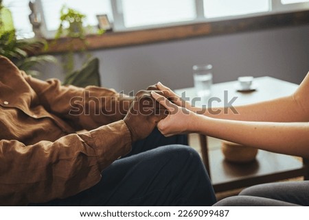 Cropped shot of a senior African american man holding hands with a nurse. Female healthcare worker holding hands of senior man at care home, focus on hands. Royalty-Free Stock Photo #2269099487