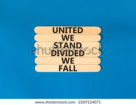 United or divided symbol. Concept words United we stand divided we fall on wooden stick. Beautiful blue table blue background. Business united or divided concept. Copy space.