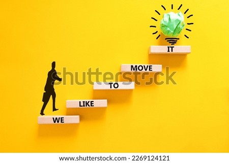 We like to move it symbol. Concept words We like to move it on wooden blocks. Businessman icon. Beautiful yellow table yellow background. Business motivational We like to move it concept. Copy space.