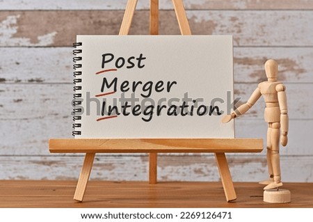 There is notebook with the word Post Merger Integration. It is an eye-catching image.