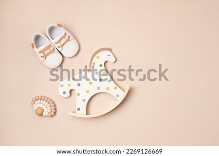 Gender neutral baby shoes, rocking horse and teether. Organic newborn fashion, branding, small business idea Royalty-Free Stock Photo #2269126669
