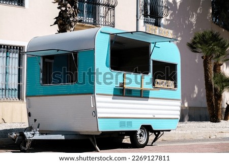 Blue and white caravan transformed into food truck with hot dog sing Royalty-Free Stock Photo #2269127811