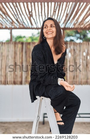 Concept Self made brunette business woman in black business suit filling positive emotions, smiling and enjoying the moment, having fun