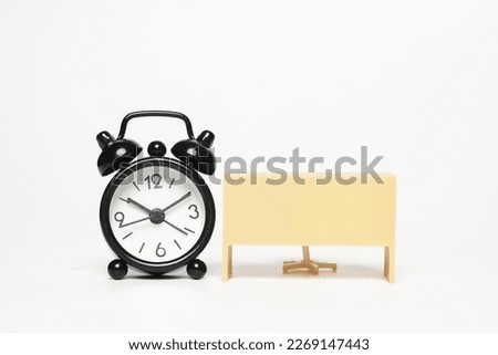 A picture of alarm clock with office desk on white background. Time to work concept.