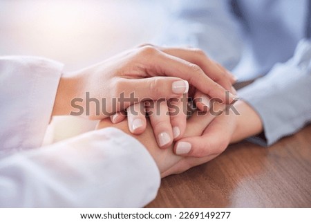 Holding hands, doctor and patient at desk for comfort, talking and communication for bad news, mental health or support. Therapist woman, cancer and together for empathy, care or wellness in hospital Royalty-Free Stock Photo #2269149277