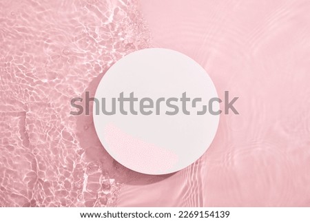 White circular empty podium, set on a pink background with water and tiny ripples. Blank for cosmetics presentation. Top view, flat lay cosmetic mockup. Royalty-Free Stock Photo #2269154139