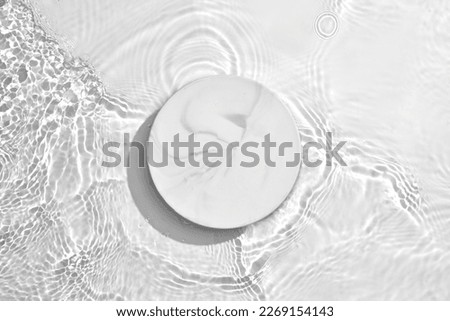 White circle podium on transparent clear water texture with splashes and waves in sunlight. Blank space for product promotion