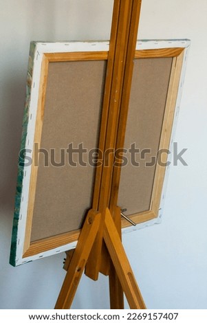 A subframe with a canvas on an easel, a view from behind