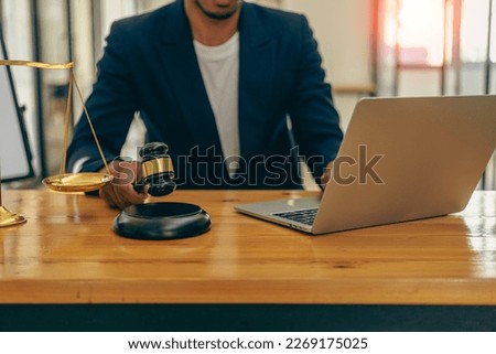 Male lawyer in suit or judge working on documents legal and justice advice Businessman working at law office and squatting with court scales and hammer