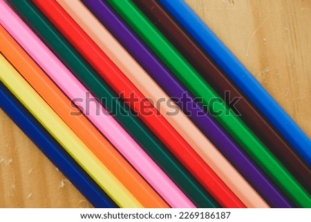 Stack of colored pencils on wooden background, Selective focus.