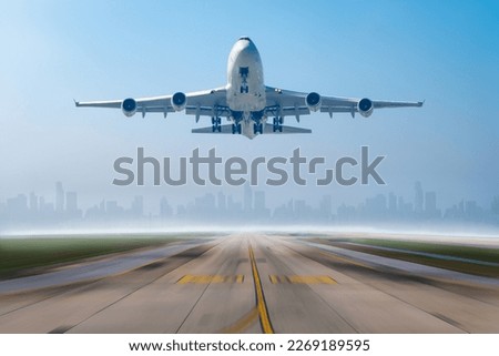 Airplane business or cargo transportation taking off from runway airport to destination with building city scape background. Royalty-Free Stock Photo #2269189595