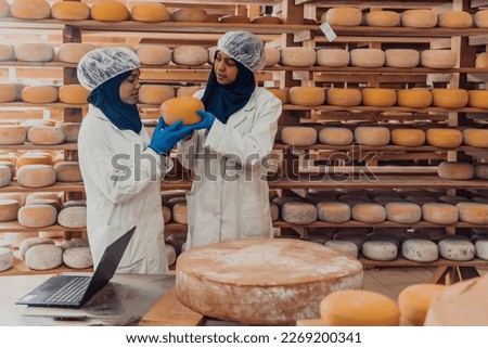 Muslim business partners checking the quality of cheese in the modern industry