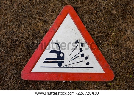 Gravel risk traffic sign. Isolated over dry grassy background