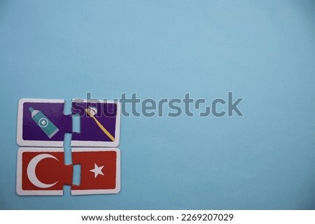 Colorfully colored puzzle pieces with toothpaste, toothbrush and Turkish flag picture placed on the lower left side of a blue background.