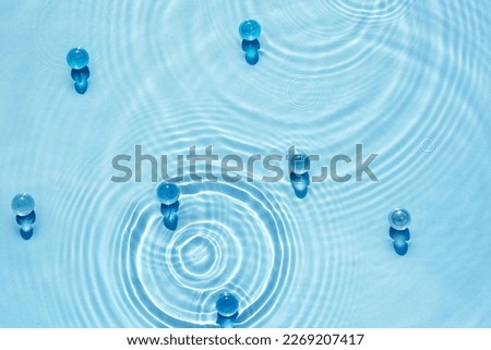 Water blue background with ripples and circles texture and transparent granules