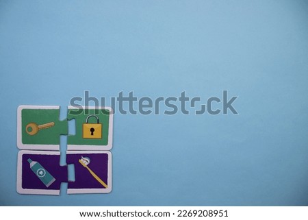 Colorfully colored puzzle pieces with pictures of keys, locks, toothbrushes, toothpaste placed on the lower left of a blue background.