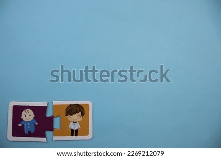 Colorfully colored jigsaw puzzle pieces with groom and baby pictures placed side by side on the lower left side of a blue background.