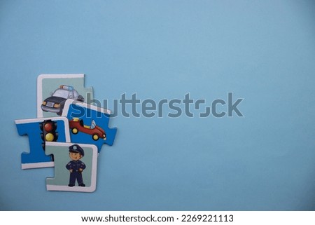 Colorfully colored picture puzzle pieces with the police in the foreground, placed at the lower left of the blue background.