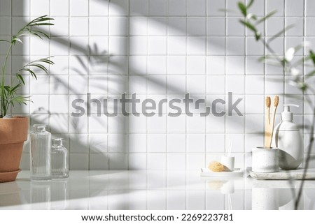 Various objects on a white tile background with warm sunlight shining through
 Royalty-Free Stock Photo #2269223781