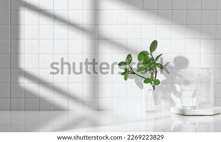 Various objects on a white tile background with warm sunlight shining through
 Royalty-Free Stock Photo #2269223829