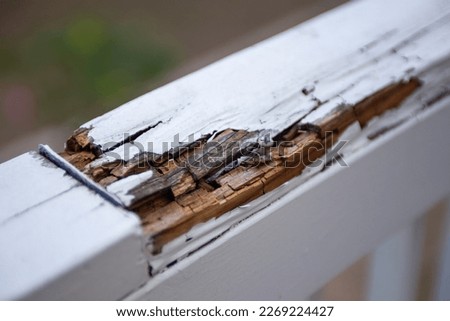 Rotting hand railing on a patio that needs to be fixed. Royalty-Free Stock Photo #2269224427