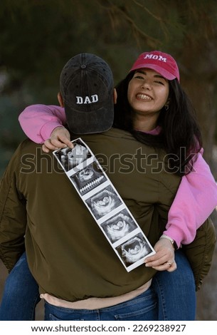 Pregnancy announcement concept. Mom  and Dad caps. Ultrasound picture of baby.