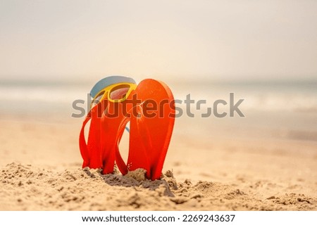 Women yellow sunglasses and red flip-flops on sandy. Travel by sea. Beach vacation.tropical sandy beach, summer travel, vacation and  summer holiday concepts. 