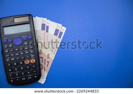 Euros and calculator placed on left of blue background