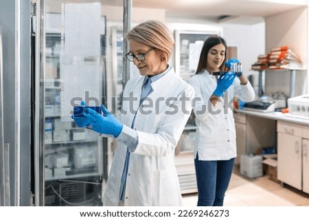 Scientist holding experiment sample in laboratory medical freezer
